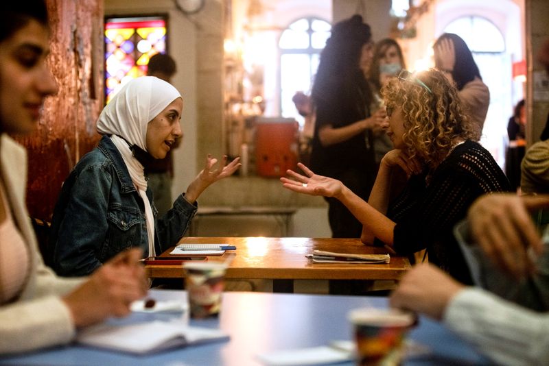 &copy; Reuters. Mujer palestina conversa con mujer israelí durante programa de intercambio lingüístico inspirado en citas rápidas, Jerusalén, 27 octubre 2021.
REUTERS/Ronen Zvulun
