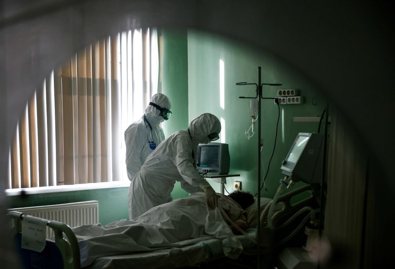 © Reuters. FILE PHOTO: Medical specialists treat a patient suffering from the coronavirus disease (COVID-19) at the intensive care unit (ICU) of the City Clinical Hospital named after S.Botkin in Oryol, Russia October 26, 2021. REUTERS/Maxim Shemetov/File Photo