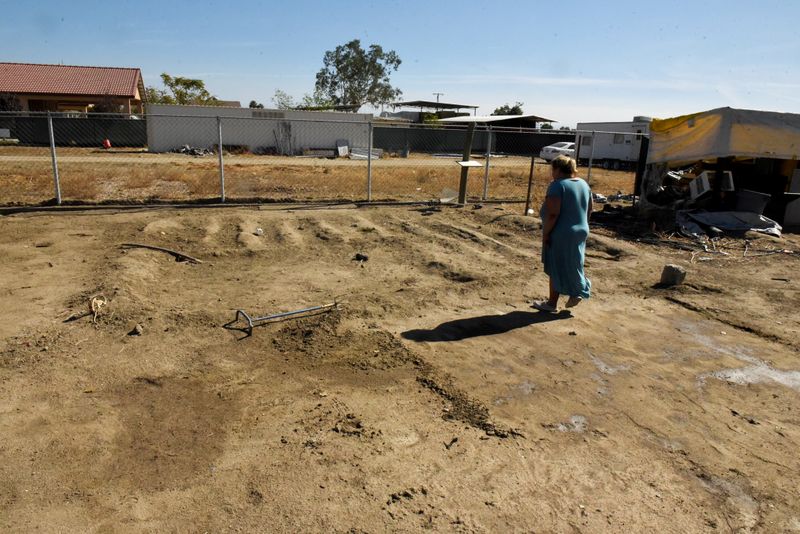 &copy; Reuters. Tiffany Copley, 40, looks at her garden that died last summer during the period when the water pump for the community went dry in Teviston, California, U.S., October 22, 2021. Picture taken on October 22, 2021.  REUTERS/Stephanie Keith