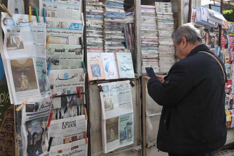 &copy; Reuters. رجل يطالع هاتفه المحمول أمام منفذ بيع صحف بالعاصمة اللبنانية بيروت. رويترز