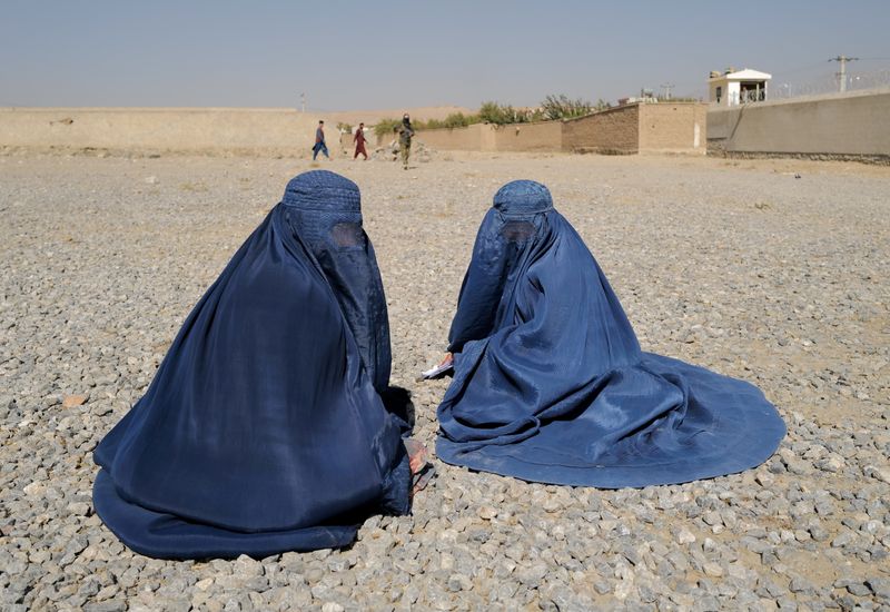 &copy; Reuters. FOTO DE ARCHIVO: Mujeres afganas desplazadas esperan para recibir la ayuda de la agencia ACNUR frente al centro de distribución en las afueras de Kabul, Afganistán, el 28 de octubre, 2021. REUTERS/Zohra Bensemra/Foto de Archivo