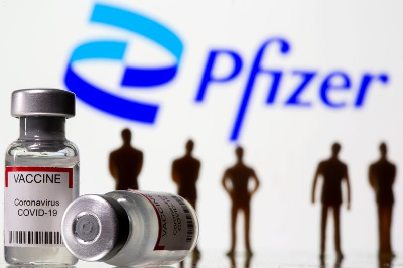 &copy; Reuters. FILE PHOTO: Syringe and vial labelled "coronavirus disease (COVID-19) vaccine" and small toy figures are seen front of displayed new Pfizer logo in this illustration taken, June 24, 2021. REUTERS/Dado Ruvic/Illustration/File Photo