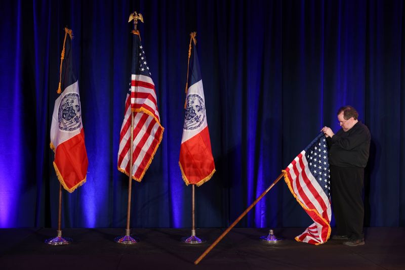 &copy; Reuters. A person adjusts a U.S. flag ahead of the election night party for Democratic candidate for New York City Mayor Eric Adams in Brooklyn, New York, U.S., November 2, 2021. REUTERS/Andrew Kelly