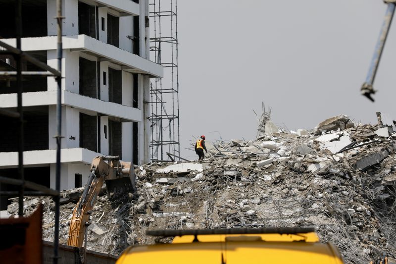 © Reuters. عامل انقاذ يعمل فوق الحطام مع استمرار جهود البحث والإنقاذ في موقع المبنى المنهار في لاجوس يوم الثلاثاء. تصوير: تميلدي أديلجا - رويترز