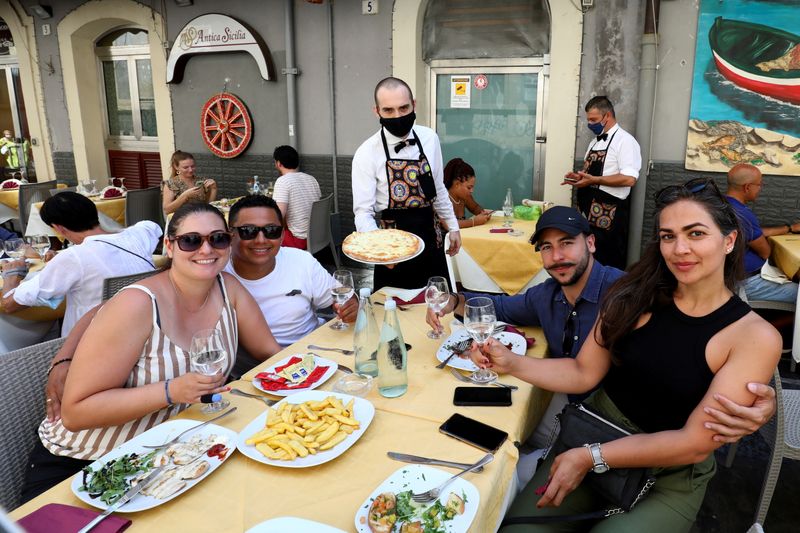 &copy; Reuters. FILE PHOTO: Diners at a restaurant pose for a photo with a server wearing a protective mask, as Sicily returns to being a 'yellow zone' with tighter coronavirus disease (COVID-19) restrictions, in Catania, Italy, August 30, 2021. REUTERS/Antonio Parrinell