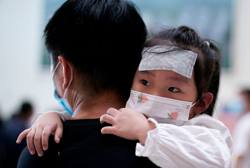&copy; Reuters. Un hombre sostiene a bebé durante una gira de medios organizada por el gobierno en el Hospital Tongji en Wuhan, China, 3 septiembre 2020.
REUTERS/Aly Song 