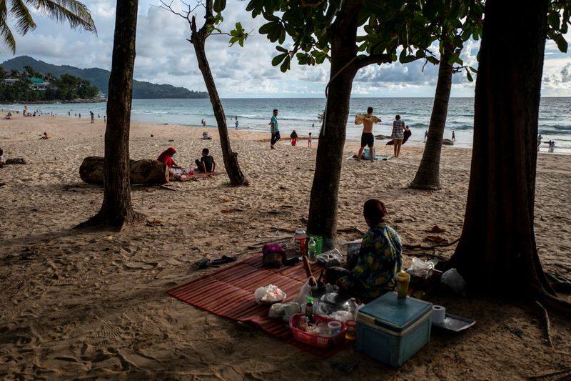 &copy; Reuters. FILE PHOTO: People enjoy at a beach as Phuket opens for foreigners, who are fully vaccinated against the coronavirus disease (COVID-19), to visit the resort island without quarantine, in Phuket, Thailand, September 19, 2021. REUTERS/Athit Perawongmetha/Fi