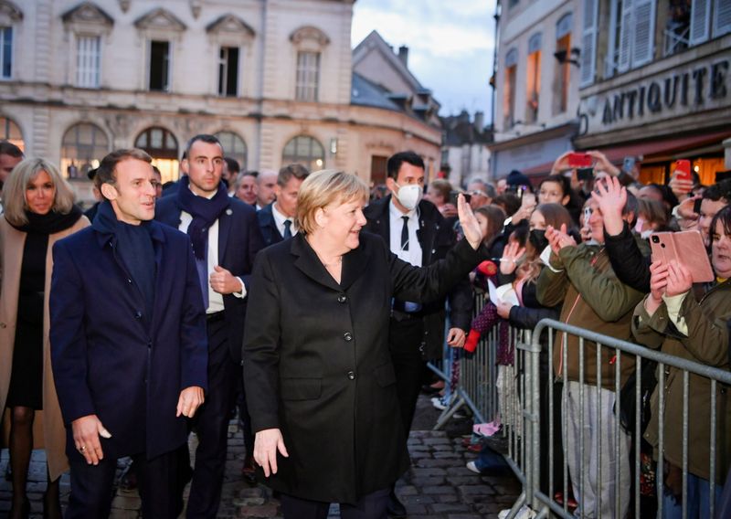 &copy; Reuters. France's President Emmanuel Macron, flanked by his wife Brigitte Macron, arrives for talks with outgoing German Chancellor Angela Merkel, in Beaune, France, November 3, 2021. Philippe Desmazes/Pool via REUTERS