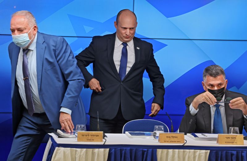 &copy; Reuters. FILE PHOTO: Israeli Prime Minister Naftali Bennett stands between Finance Minister Avigdor Lieberman and Justice Minister Gideon Saar at a news conference on economy in Jerusalem, July 6, 2021. Menahem Kahana/Pool via REUTERS