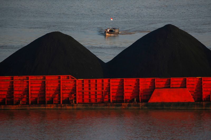 © Reuters. A man stands on a boat as coal barges queue to be pulled along Mahakam river in Samarinda, East Kalimantan province, Indonesia, August 31, 2019. Picture taken August 31, 2019. REUTERS/Willy Kurniawan