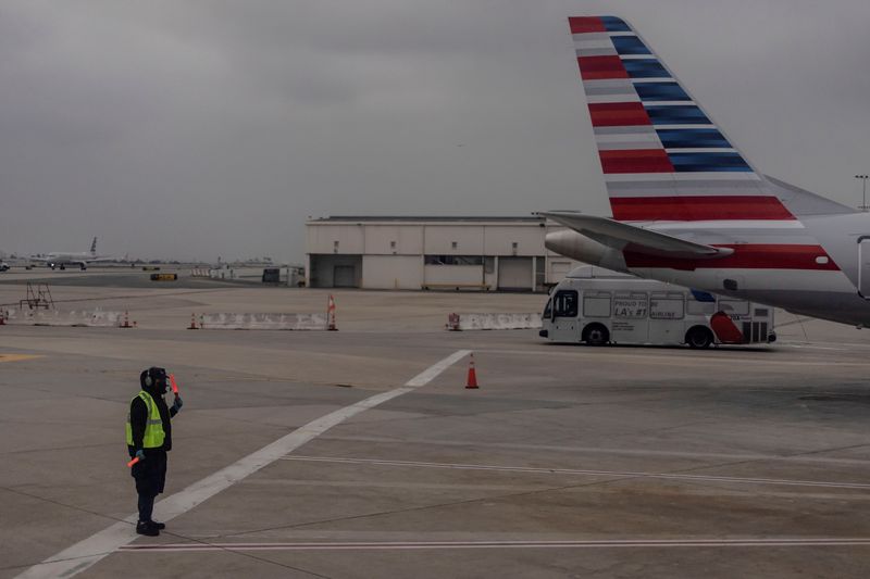 © Reuters. FILE PHOTO: An American Airlines worker is seen at the Los Angeles international airport as more than 1,400 American Airlines flights over the weekend have been canceled due to staff shortages and unfavorable weather in Los Angeles, California, U.S., October 31, 2021. REUTERS/Carlos Barria