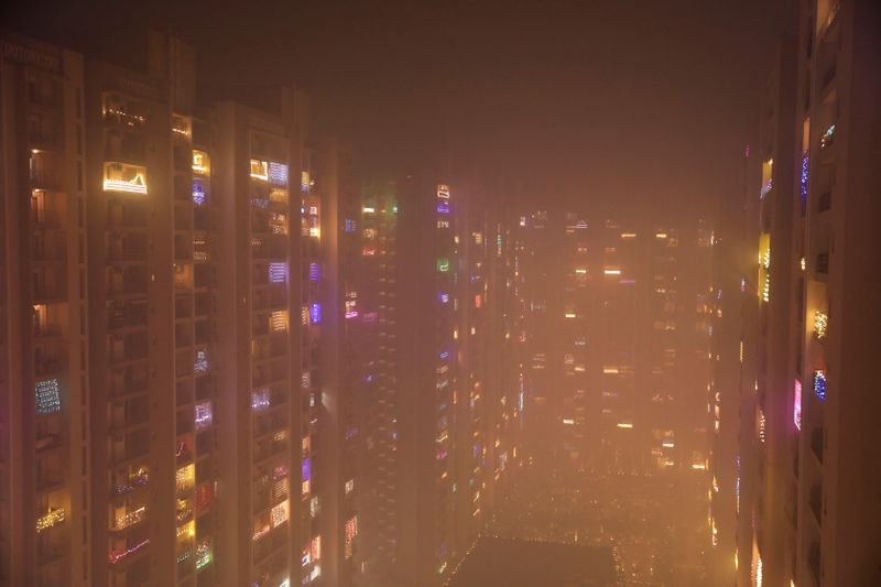 © Reuters. Lights decorating the balconies of a high-rise are seen shrouded in smog in Noida, India, November 5, 2021. REUTERS/Anushree Fadnavis