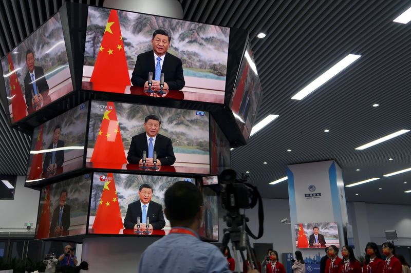 &copy; Reuters. FILE PHOTO: Chinese President Xi Jinping is seen on television screens at a media centre as he delivers a speech via video at the opening ceremony of the China International Import Expo (CIIE) in Shanghai, China November 4, 2021. REUTERS/Andrew Galbraith