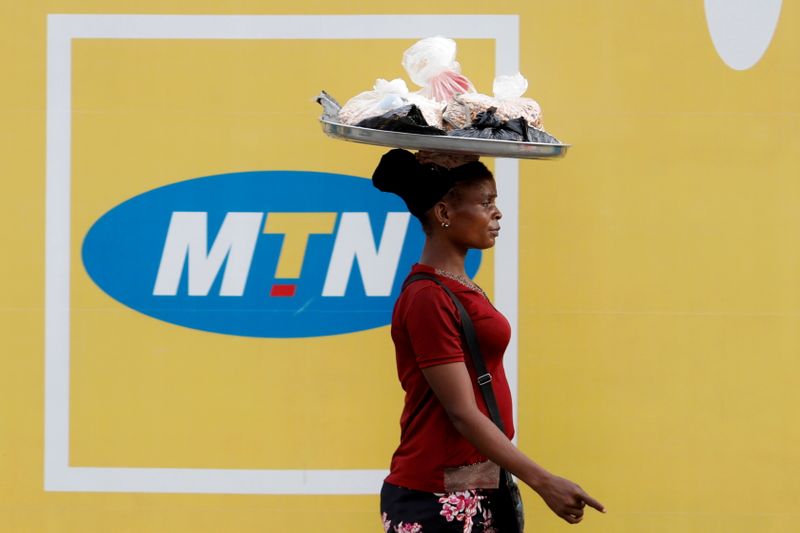 © Reuters. FILE PHOTO: A woman walks past an advertising posters for MTN telecommunication company along a street in Lagos, Nigeria August 28, 2019. REUTERS/Temilade Adelaja/File Photo