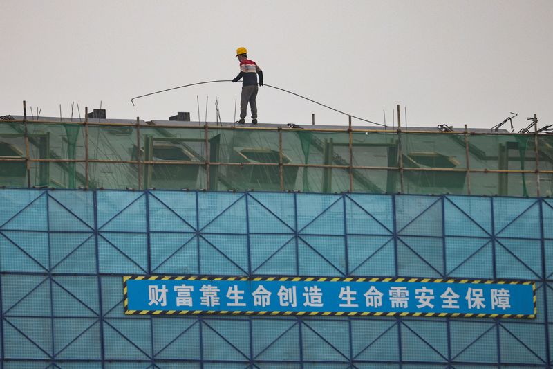 © Reuters. A man walks on a scaffolding at the construction site of the Beijing Xishan Palace apartment complex developed by Kaisa Group Holdings Ltd in Beijing, China, November 5, 2021.  REUTERS/Thomas Peter