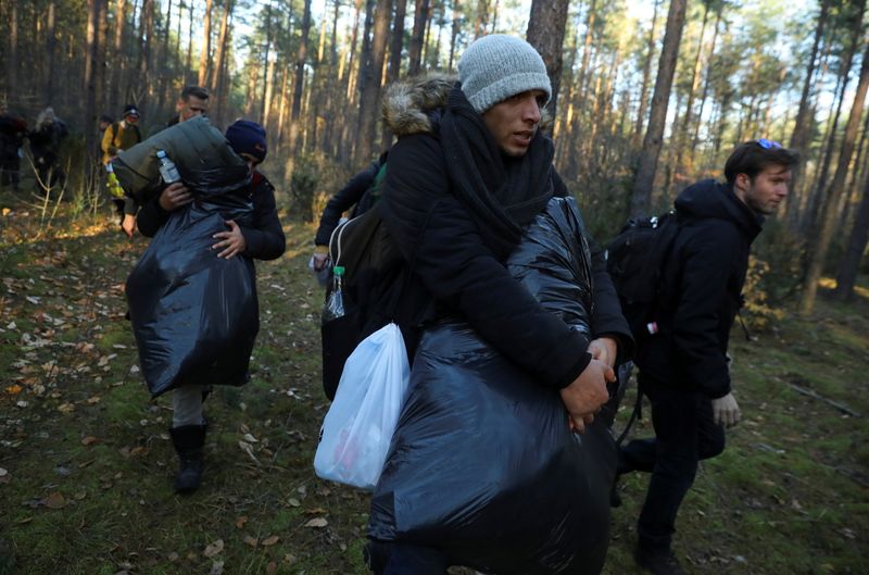 &copy; Reuters. FOTO DE ARCHIVO: Un joven sirio carga con sus pertenencias a través de un bosque tras cruzar la frontera entre Bielorrusia y Polonia en Lewosze, Polonia, el 29 de octubre de 2021. REUTERS/Kacper Pempel