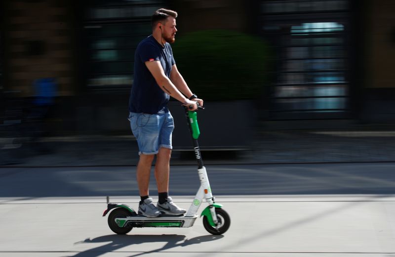 © Reuters. FILE PHOTO: A man rides an e-scooter from Lime, a U.S. based transportation-rental company running bicycle-, scooter- and car-sharing systems, in Cologne, Germany, July 23, 2019. REUTERS/Wolfgang Rattay