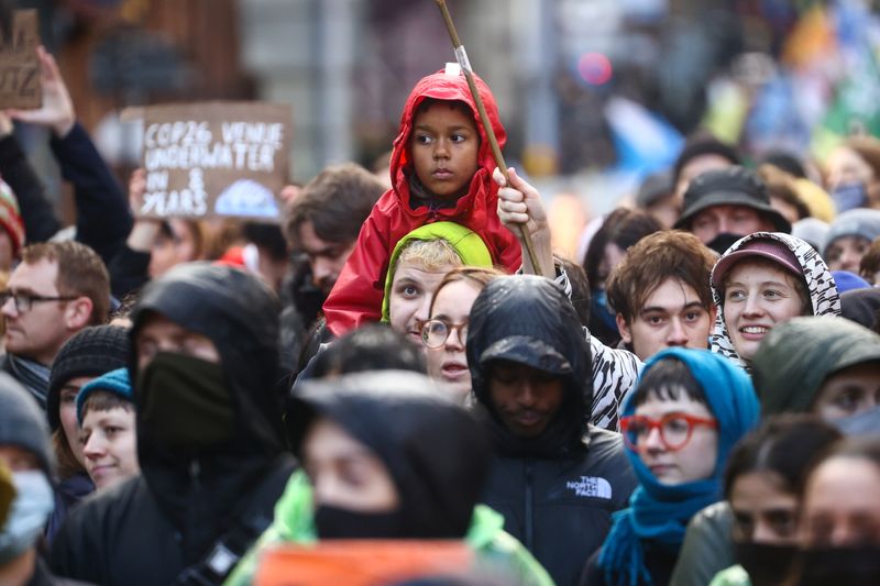 © Reuters. أشخاص يشاركون في احتجاج خلال مؤتمر الأمم المتحدة للمناخ في جلاسجو باسكتلندا يوم السبت. تصوير:رويترز.
