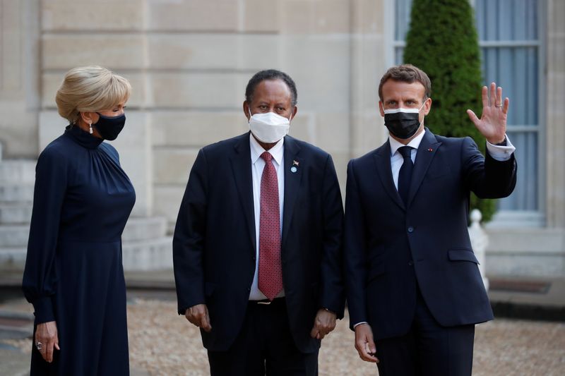 © Reuters. صورة من أرشيف رويترز للرئيس الفرنسي ايمانويل ماكرون وزوجته وبينهما رئيس الوزراء السوداني المعزول عبد الله حمدوك في قصر الاليزيه.