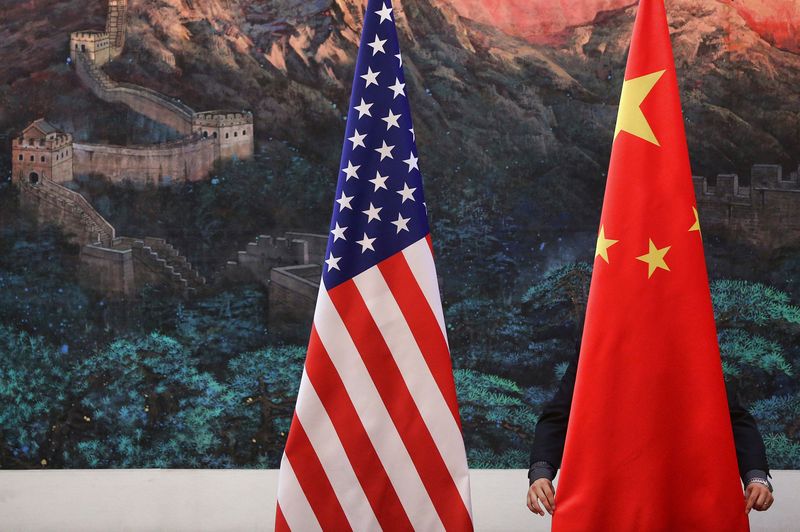 &copy; Reuters. رجل يضبط علم الصين بجانب علم الولايات المتحدة في بكين - صورة من أرشيف رويترز 