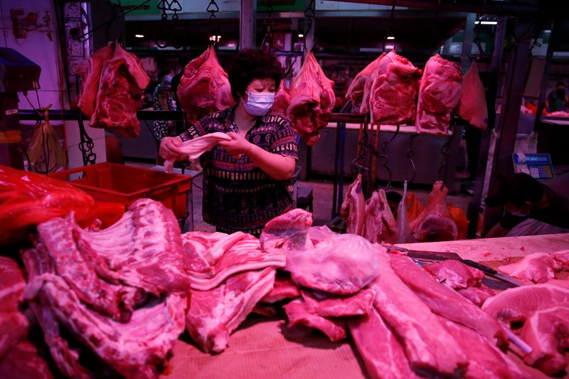 &copy; Reuters. 　１１月８日、中国税関総署の統計によると、１０月の食肉輸入は６６万４０００トンと前年同月比１２．８％減少した。写真は北京の卸売り市場で豚肉の準備をする様子。昨年６月撮影（