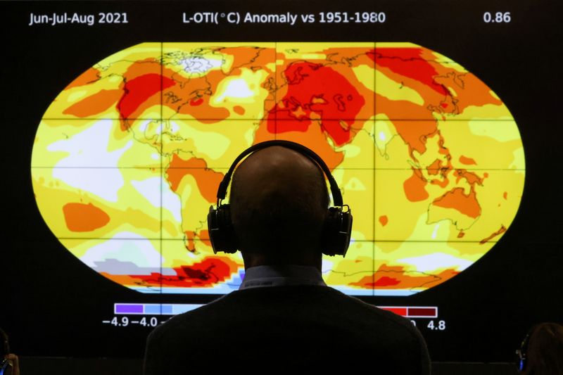 © Reuters. أحد المشاركين في قمة الأمم المتحدة للمناخ المنعقدة في جلاسجو باسكتلندا ينظر إلى شاشة تعرض لكوكب الأرض يوم الاثنين. تصوير:رويترز.

