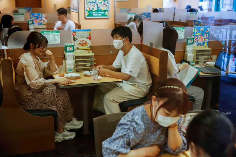 © Reuters. FILE PHOTO: People sit in a restaurant using plexiglass separators to protect customers from coronavirus (COVID-19) disease in the Shibuya area of Tokyo, Japan, July 29, 2021. REUTERS/Androniki Christodoulou