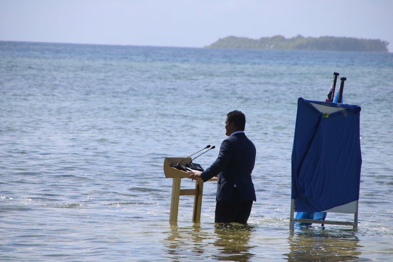 &copy; Reuters. FILE PHOTO: Tuvalu's Minister for Justice, Communication & Foreign Affairs Simon Kofe gives a COP26 statement while standing in the ocean in Funafuti, Tuvalu November 5, 2021. Courtesy Tuvalu's Ministry of Justice, Communication and Foreign Affairs / Soci