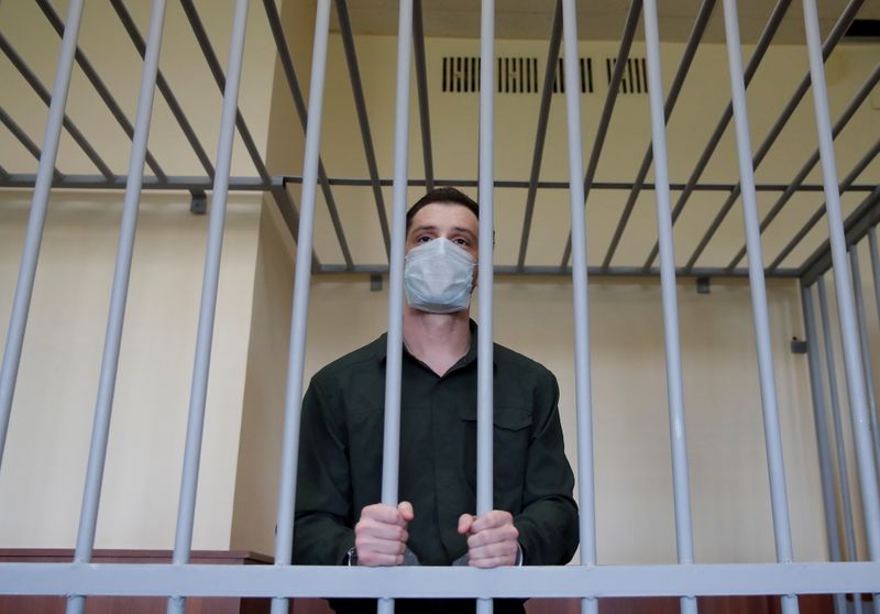 &copy; Reuters. FILE PHOTO: Former U.S. Marine Trevor Reed, who was detained in 2019 and accused of assaulting police officers, stands inside a defendants' cage during a court hearing in Moscow, Russia July 30, 2020. REUTERS/Maxim Shemetov