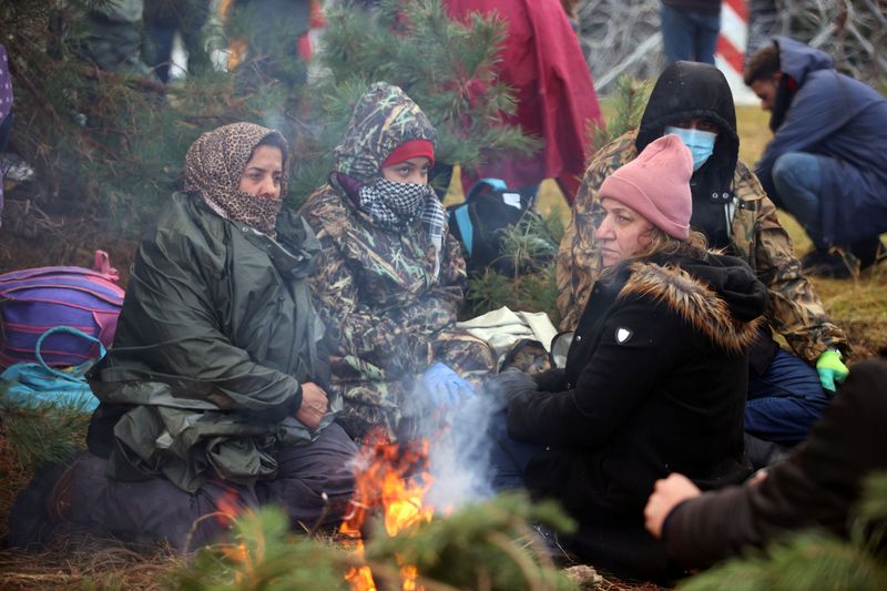 &copy; Reuters. Varias personas sentadas en torno a una hoguera cerca de la frontera vallada entre Bielorrusia y Polonia en la región de Grodno, Bielorrusia, el 8 de noviembre de 2021. Leonid Scheglov/BelTA/Cedida a través de REUTERS