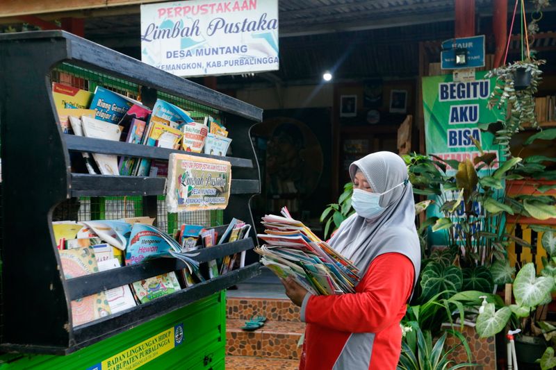 &copy; Reuters. Raden Roro Hendarti, de 48 años y fundadora de la biblioteca de la basura (Limbah Pustaka), ordena libros en un vehículo de tres rudas en la biblioteca en la aldea de Muntang, Purbalingga, provincia de Java Central, Indonesia. 2 de noviembre, 2021. REUT