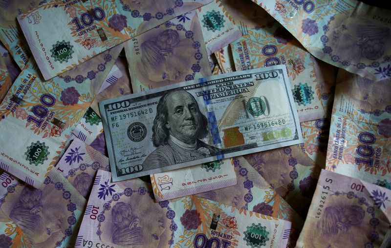 &copy; Reuters. FILE PHOTO: Argentine one hundred peso bills sit underneath United States one hundred dollar bill in this picture illustration taken September 3, 2019. REUTERS/Agustin Marcarian/Illustration/File Photo