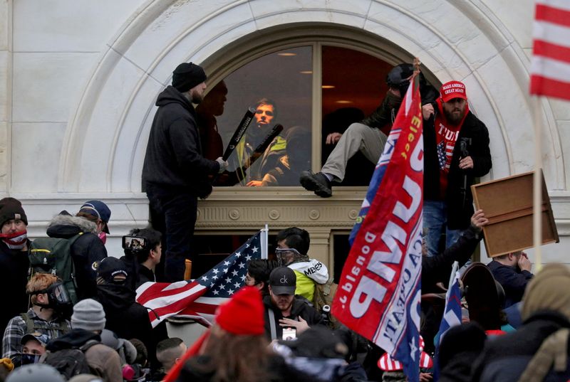 © Reuters. حشد من أنصار الرئيس الأمريكي دونالد ترامب يتسلقون ويدخلون عبر نافذة حطموها عند اقتحام مبنى الكابيتول في واشنطن يوم  6 يناير كانون الثاني 2021. تصوير:رويترز.
