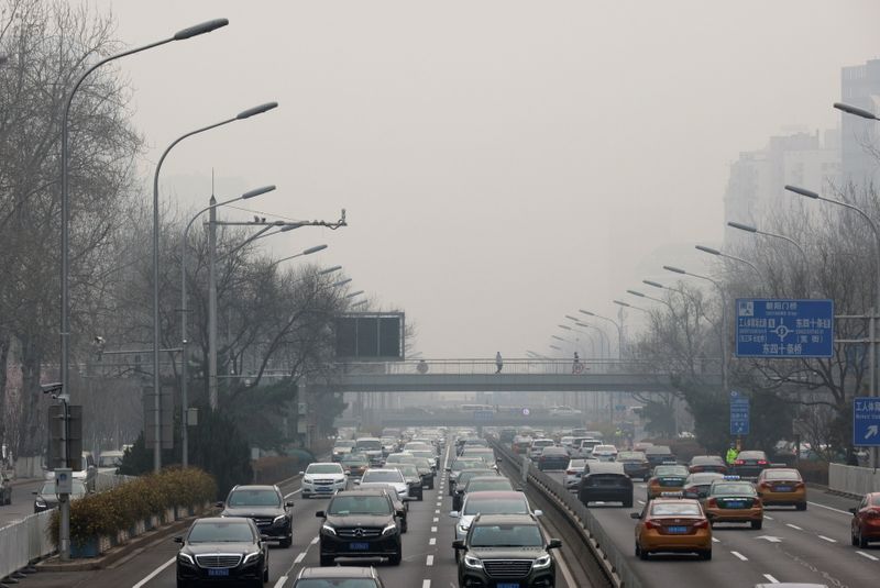 &copy; Reuters. FILE PHOTO: Cars drive in the city centre, on the day of closing session of the Chinese People's Political Consultative Conference (CPPCC), during a polluted day in Beijing, China, March 10, 2021. REUTERS/Thomas Peter/File Photo