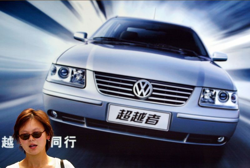 &copy; Reuters. FILE PHOTO: A Chinese commuter walks past an advertisement for Volkswagen Santana Conqueror in Shanghai July 12, 2004. REUTERS/Claro Cortes IV