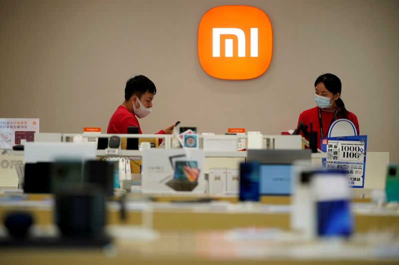 &copy; Reuters. Staff members stand near the company logo at a Xiaomi store in Shanghai, China November 1, 2021. REUTERS/Aly Song