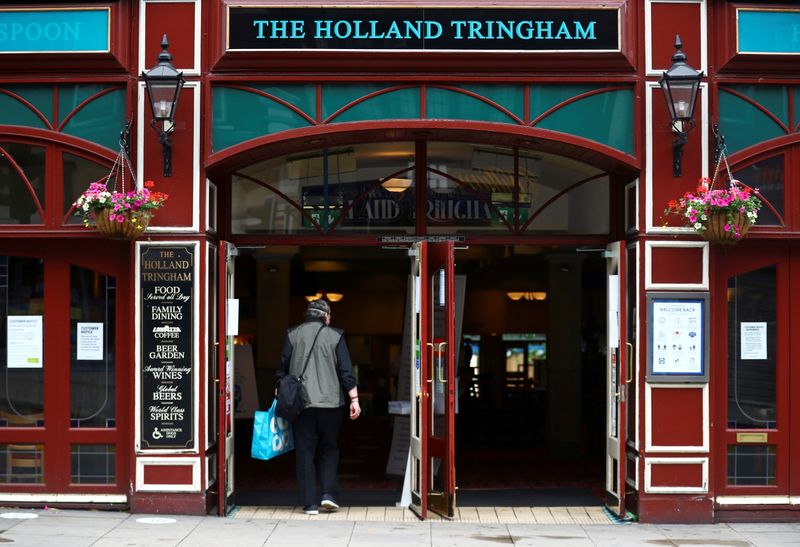 &copy; Reuters. FILE PHOTO: A customer enters The Holland Tringham Wetherspoons pub after reopened, following the outbreak of the coronavirus disease (COVID-19), in London, Britain July 4, 2020. REUTERS/Hannah McKay