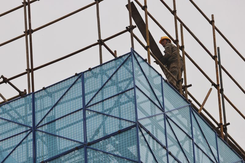 &copy; Reuters. FILE PHOTO: A man walks on a scaffolding at the construction site of the Beijing Xishan Palace apartment complex developed by Kaisa Group Holdings Ltd in Beijing, China, November 5, 2021.  REUTERS/Thomas Peter