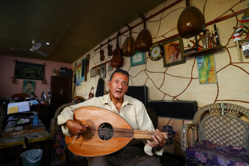 &copy; Reuters. معلم الموسيقى الفلسطيني خضر البايض في منزله في غزة يوم 7 نوفمبر تشرين الثاني 2021. تصوير: محمد سالم - رويترز.