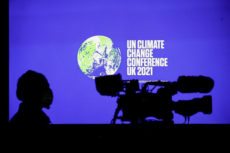 &copy; Reuters. Cinegrafista em frente ao logo da COP26 durante entrevista coletiva em Glasgow
05/11/2021 REUTERS/Phil Noble