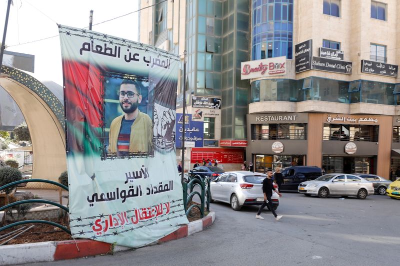 &copy; Reuters. صورة الفلسطيني مقداد القواسمي على لافتة في شارع في الخليل بالضفة الغربية يوم الأربعاء. تصوير: موسى عيسى قواسمة - رويترز.