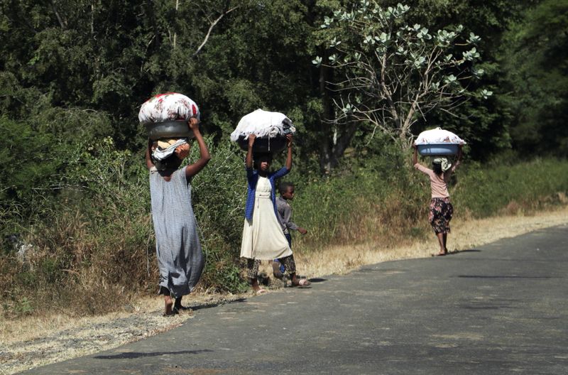 © Reuters. فتيات يحملن ملابس في بلدة سوروكا في اقليم أمهرة بالقرب من الحدود مع اقليم تيجراي في اثيوبيا يوم الثلاثاء. تصوير: تيكسا نيجيري - رويترز.