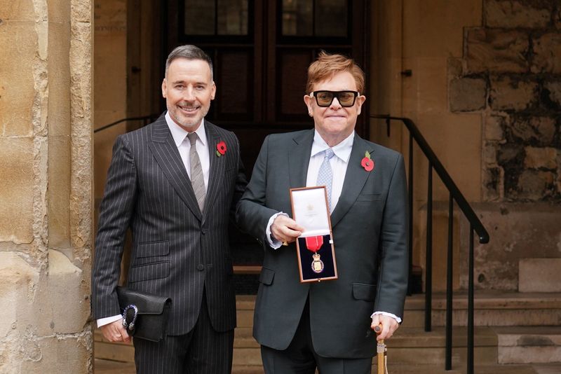 © Reuters. El músico Elton John (derecha), junto a su marido David Furnish, tras ser nombrado miembro de la Orden de los Compañeros de Honor por sus servicios a la música y a la caridad durante una ceremonia de investidura en el Castillo de Windsor, en Gran Bretaña, el 10 de noviembre de 2021. Dominic Lipinski/Pool vía REUTERS