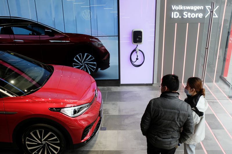 © Reuters. FILE PHOTO: People check a Volkswagen ID.4 X electric vehicle displayed inside an ID. Store X showroom of SAIC Volkswagen in Chengdu, Sichuan province, China January 10, 2021. REUTERS/Yilei Sun