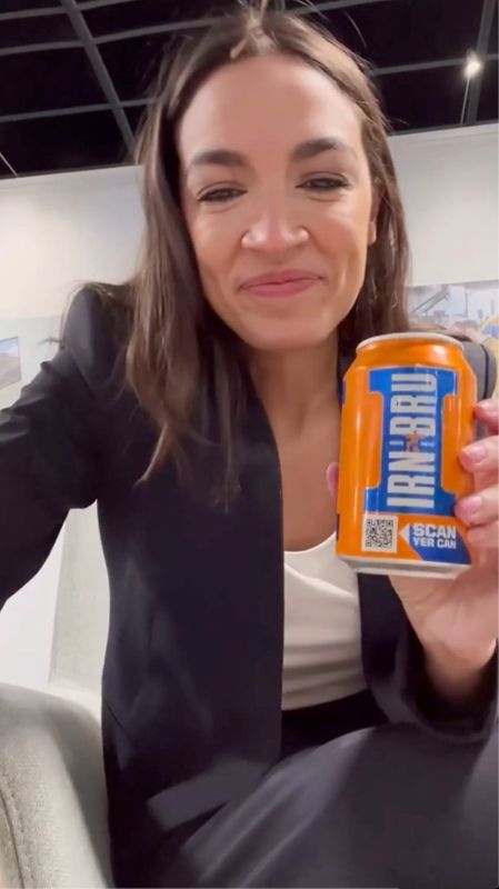 &copy; Reuters. U.S. Representative Alexandria Ocasio-Cortez (D-NY) shows a can of Irn-Bru provided by Scotland's First Minister Nicola Sturgeon (not pictured) in this still frame obtained from November 10, 2021 handout video in Glasgow, Scotland. ALEXANDRIA OCASIO-CORTE