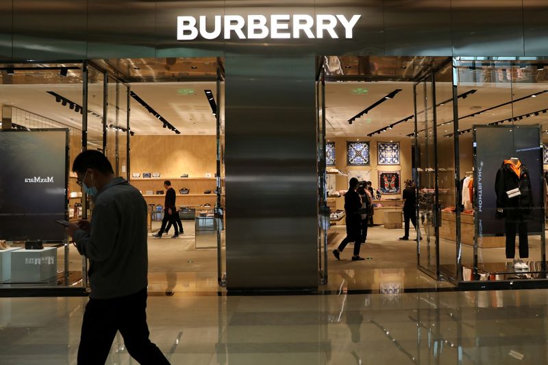 &copy; Reuters. Un passante davanti a un negozio del marchio di lusso Burberry in un centro commerciale a Pechino, Cina, 26 marzo 2021. REUTERS/Tingshu Wang