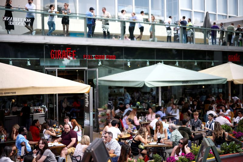 © Reuters. FILE PHOTO: People sit at an outdoor restaurant on the South Bank during sunny weather, amid the coronavirus disease (COVID-19) outbreak, in London, Britain, June 5, 2021. REUTERS/Henry Nicholls