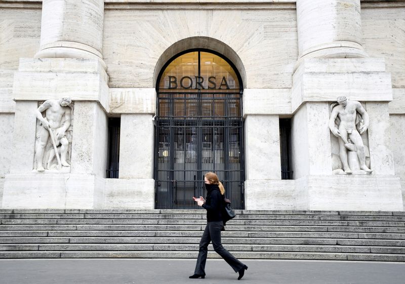 &copy; Reuters. FOTO DE ARCHIVO: Una mujer pasa por delante de la Bolsa italiana en Milán, mientras el país se ve afectado por el brote de coronavirus. Italia.26 REUTERS/Flavio Lo Scalzo