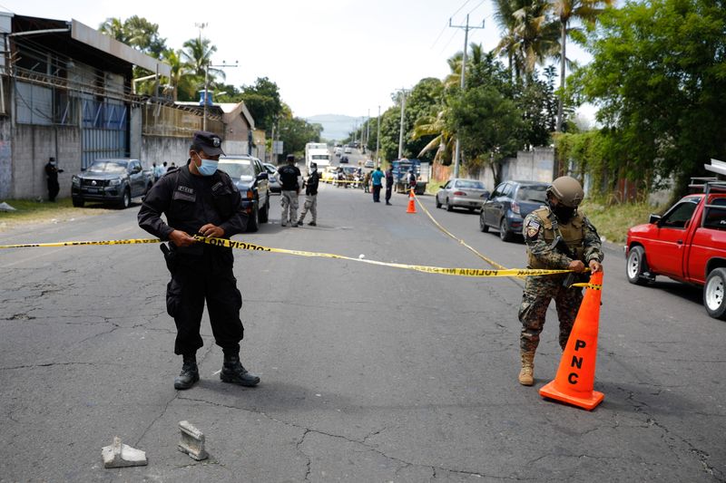 © Reuters. A police officer and a soldier tape off a crime scene where a man was killed inside a car, as Salvadoran President Nayib Bukele deploys military to patrol the streets throughout the country in response to a sharp surge in murders this week, in San Martin, El Salvador November 11, 2021. REUTERS/Jose Cabezas