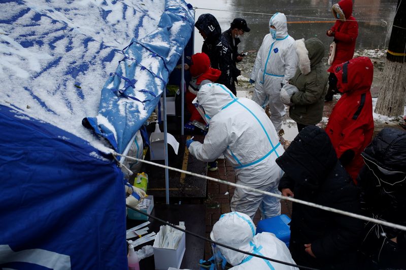 &copy; Reuters. People line up for nucleic acid testing in the snow at a testing site in Jinpu New Area, following cases of the coronavirus disease (COVID-19) in Dalian, Liaoning province, China November 8, 2021. cnsphoto via REUTERS